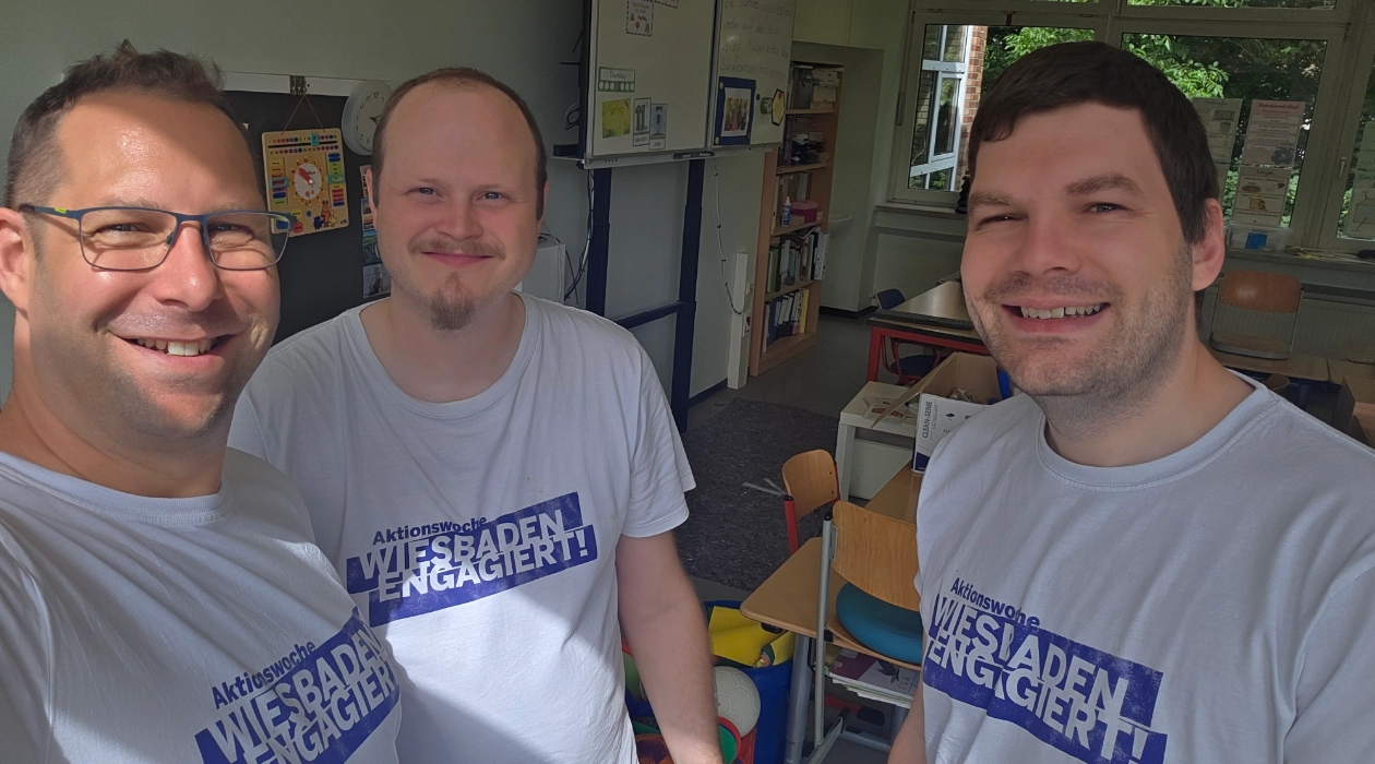 Mitarbeiter von blecon im stehen im Halbkreis und haben T-Shirts von Wiesbaden Engagiert an. Alle lachen und freuen sich.