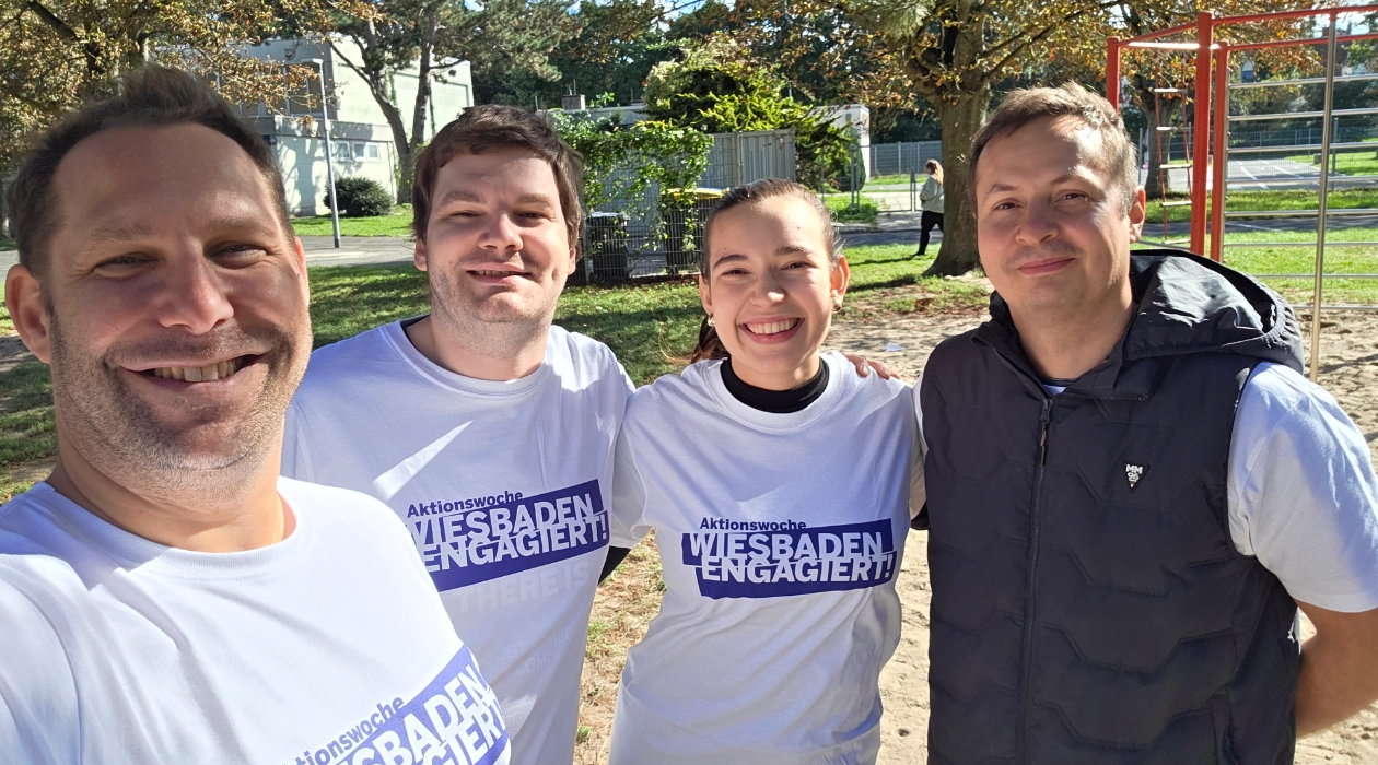 Mitarbeiter von blecon im stehen im Halbkreis und haben T-Shirts von Wiesbaden Engagiert an. Alle lachen und freuen sich.